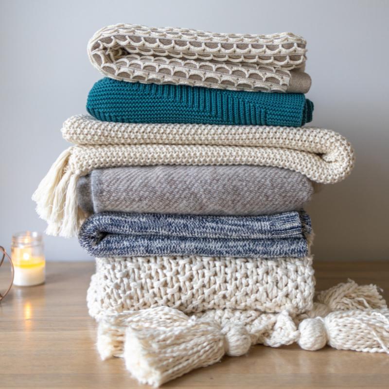 pile de plaids de tailles, matières et couleurs différentes