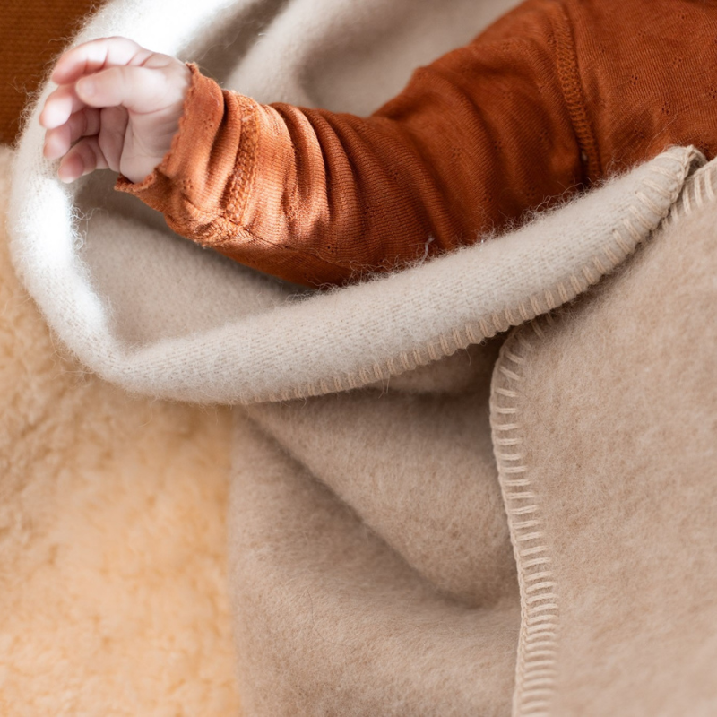 Plaid laine avec une main de bébé qui dépasse