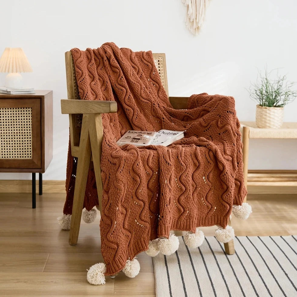 Plaid tricot terracotta sur un fauteuil