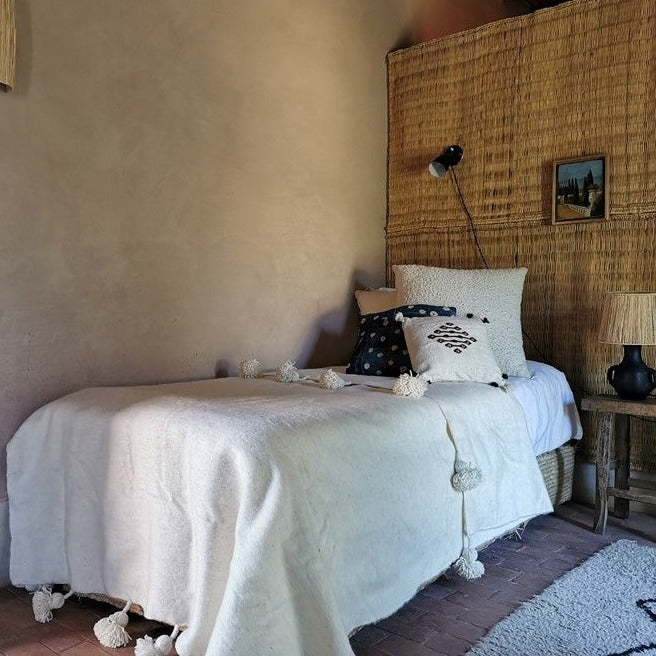 Plaid berbère blanc sur un lit avec des oreiller