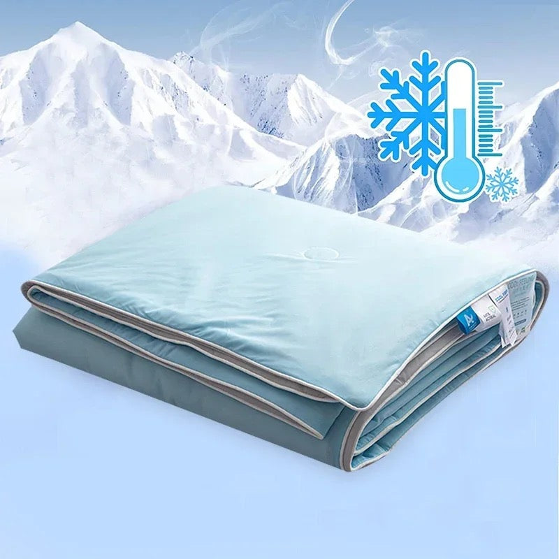 Plaid d'été rafraîchissant bleu plié, posé devant un décor de montagnes enneigées, avec icône thermomètre glacé