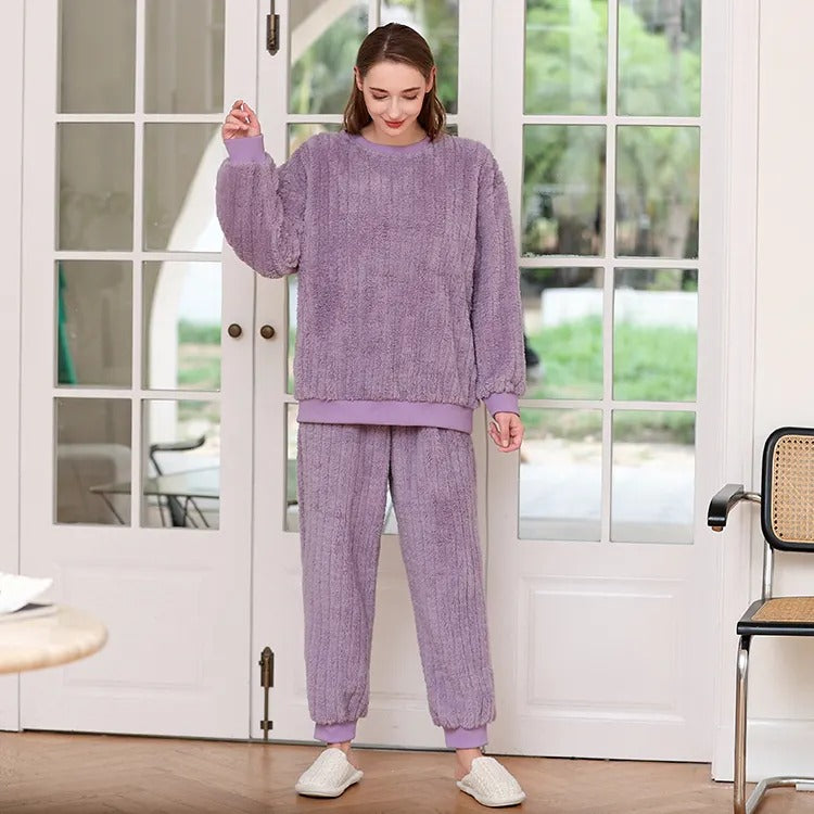 femme portant un pyjama plaid cocooning violet debout devant une porte fenêtre