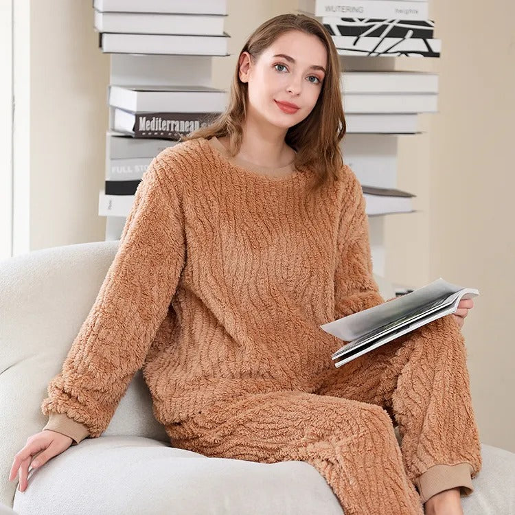 femme portant un pyjama plaid cocooning marron assise avec un livre en main