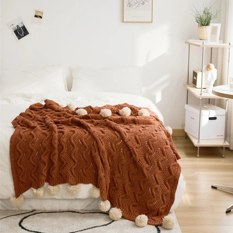 Plaid tricot terracotta sur un lit