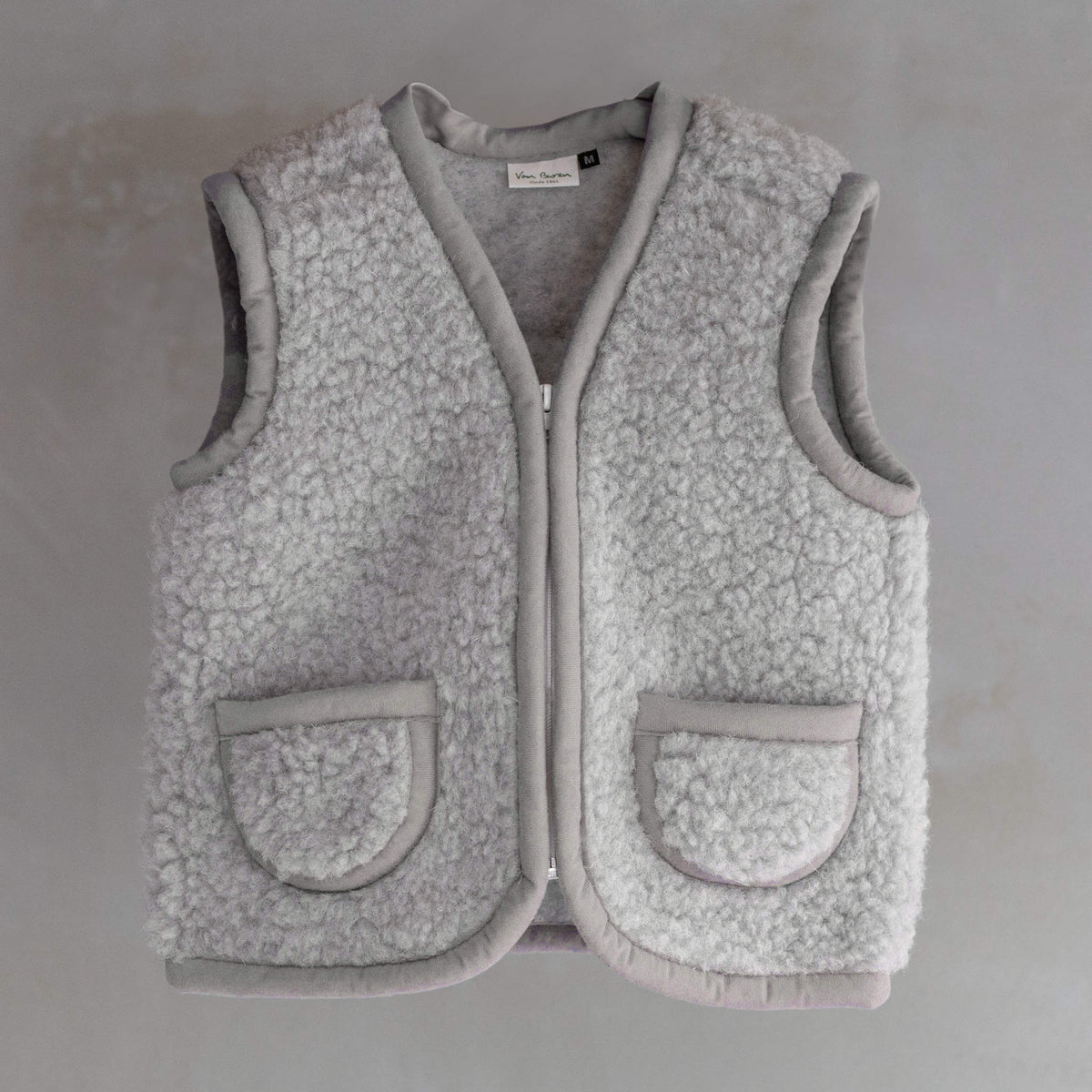 Gilet sans manches en laine pour enfant gris, vu de face, fermeture éclair et poches